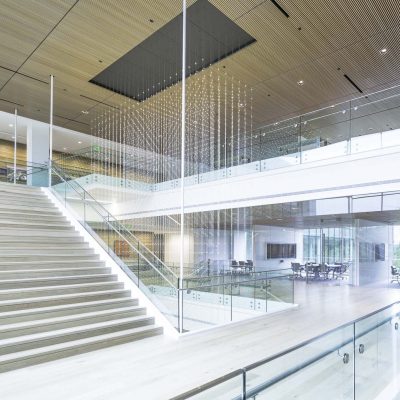 9Wood 1400 Dowel/Cross Piece Grille at Hillwood Offices at Turtle Creek, Dallas, Texas. Mithun; BOKA Powell. Photo: Irish Coffee Studio. A light sculpture hangs from the third floor. Adjacent wood grilles were field cut to create the perimeter of the rectangular space.