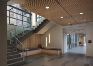 http://The%209Wood%201400%20Dowel%20Cross%20Piece%20Grille%20in%20White%20Maple%20Veneer,%20Clear%20Finish%20features%20integrated%20can%20lighting%20and%20matching%20Wall%20Grille%20in%20an%20education%20setting.