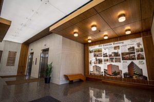 http://The%209Wood%204500%20XL%20Channel%20Tile%20in%20Walnut%20Veneer%20in%20an%20office%20lobby%20setting.